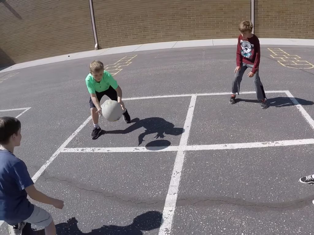 four kids play four square game
